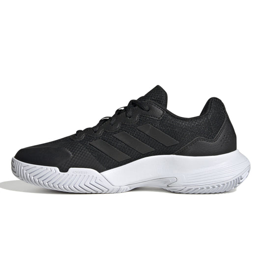 Black Adidas tennis shoe with white sole on a white background