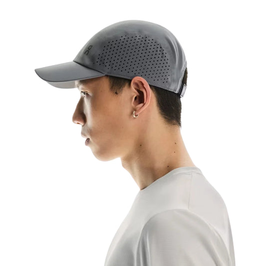 Side view of a man wearing a grey On cap on a white background