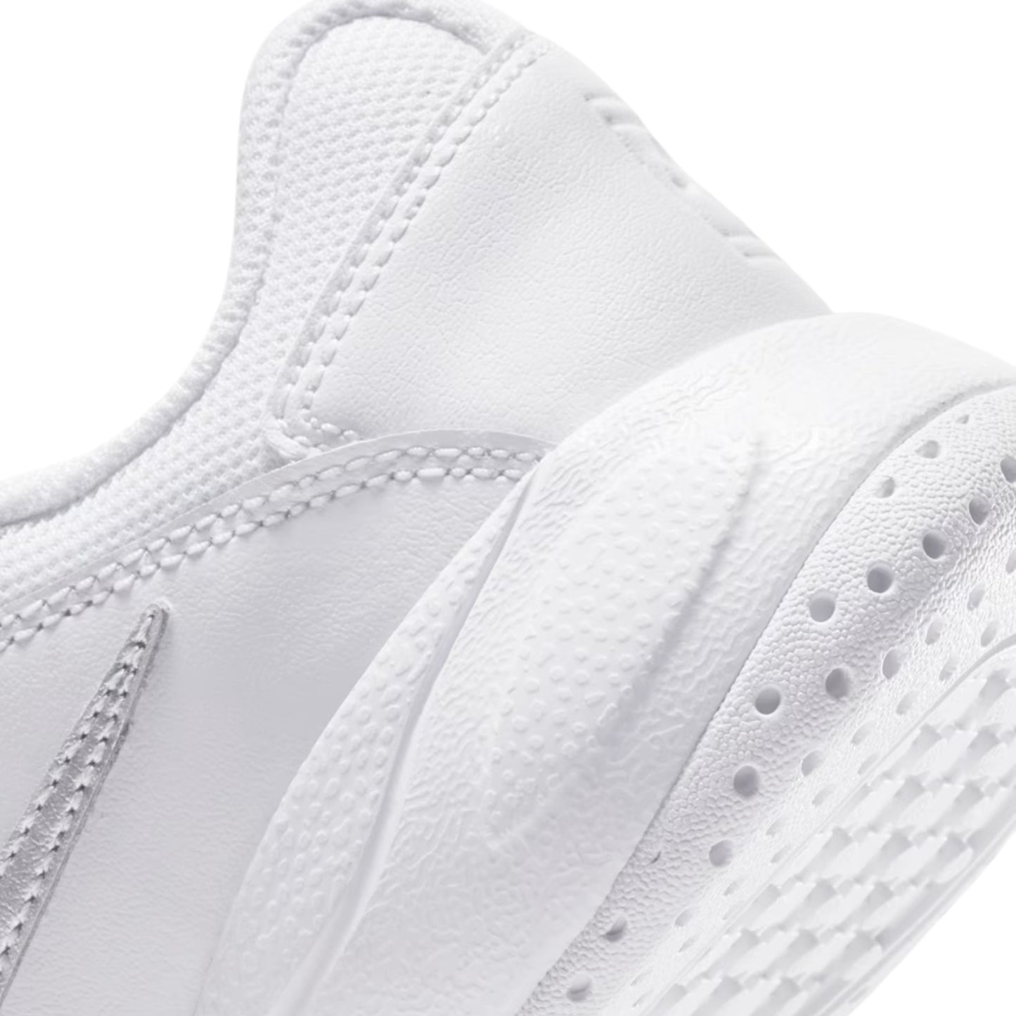 Close-up of a white tennis shoe with detailed stitching and sole texture.