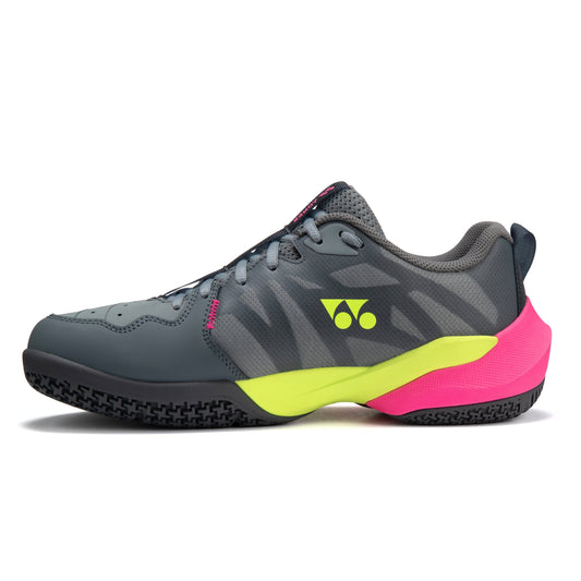 Gray Yonex squash shoe with pink and yellow sole on a white background
