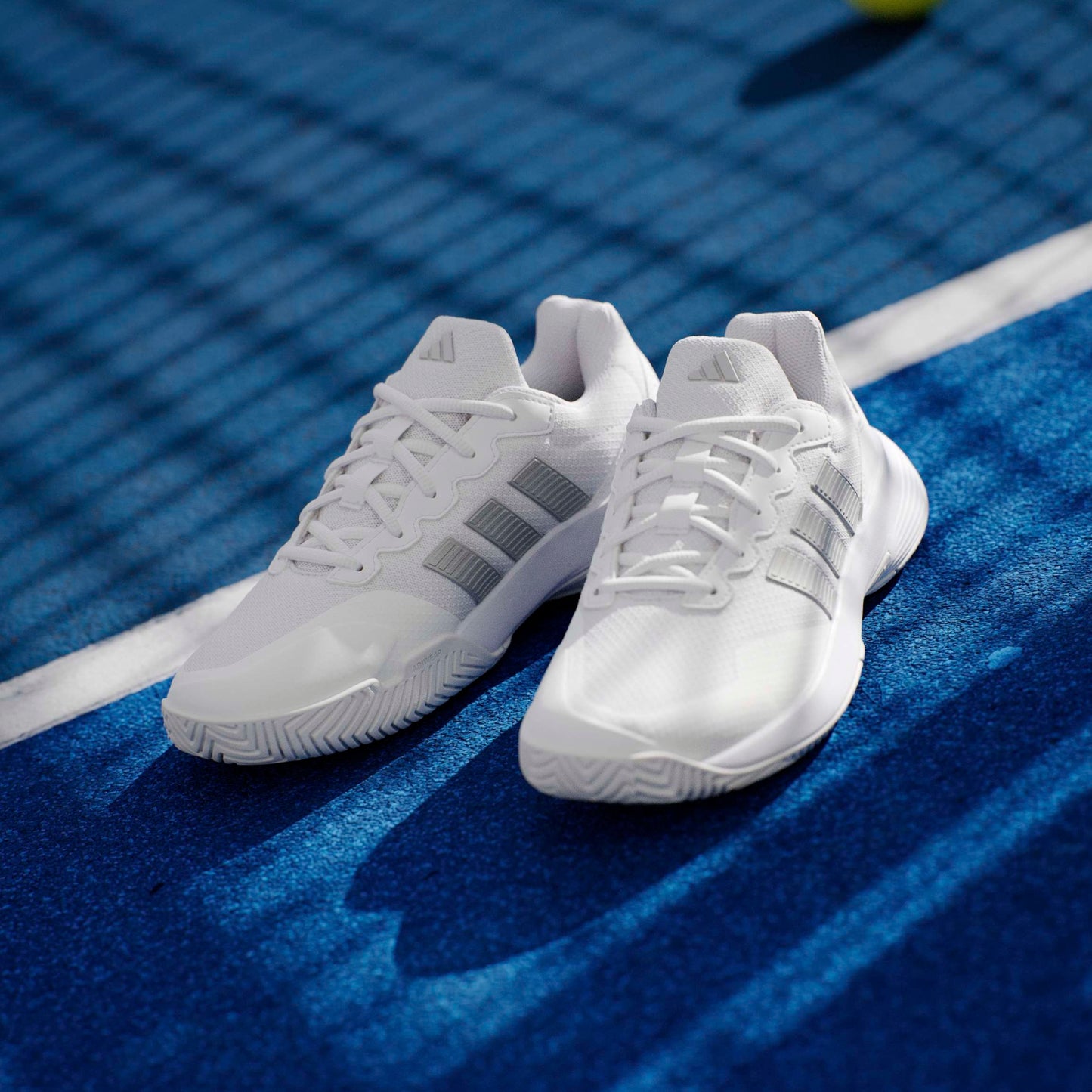 White tennis shoes on a blue court