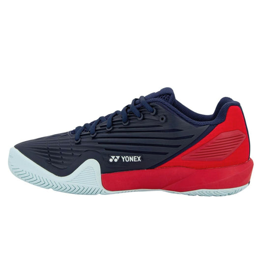 Navy and red Yonex tennis shoe with a brand logo on a white background
