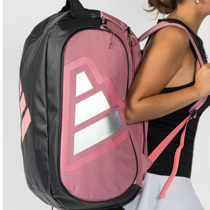 Person wearing a pink and black adidas padel bag with a visible brand logo.