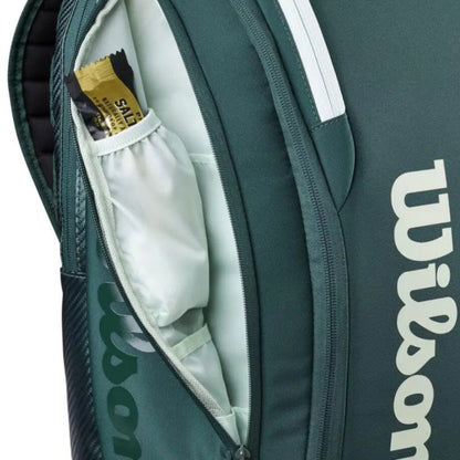 Green Wilson tennis bag with a white interior and visible brand logo.
