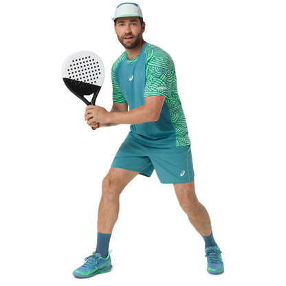 Man in teal athletic outfit holding a paddle on a white background