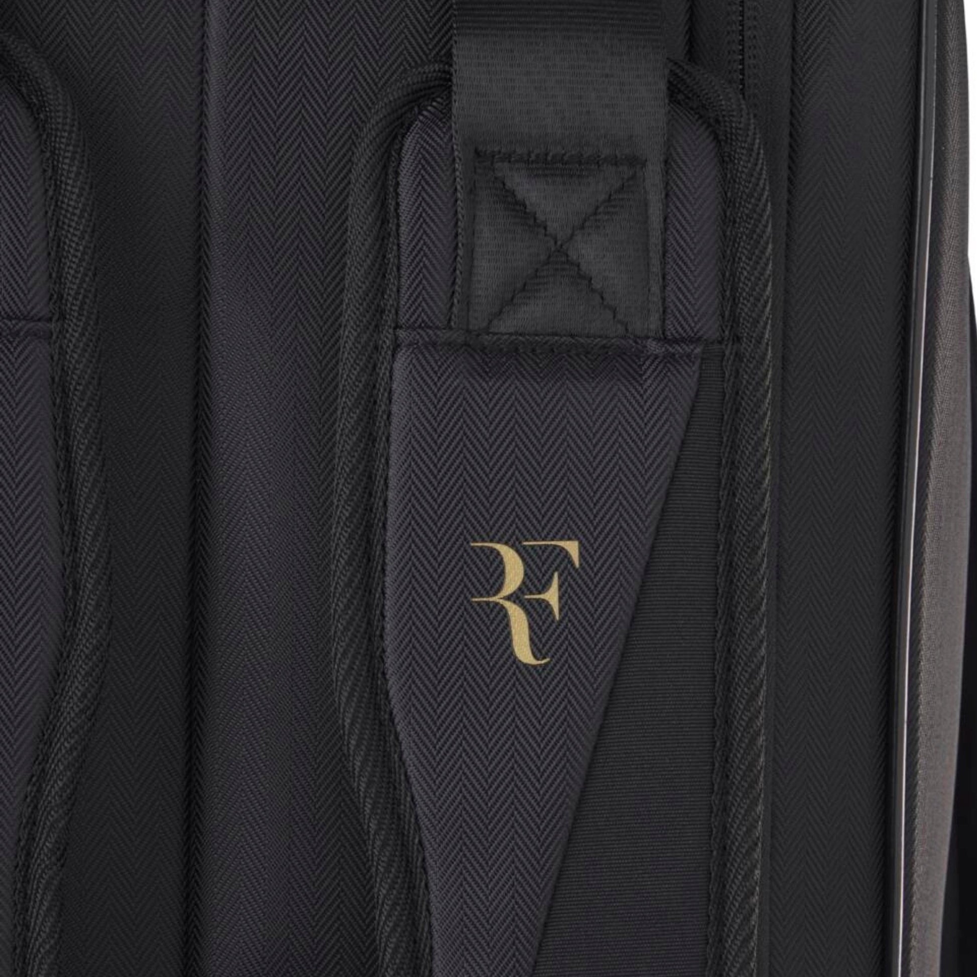 Black tennis bag with a gold logo on a black background