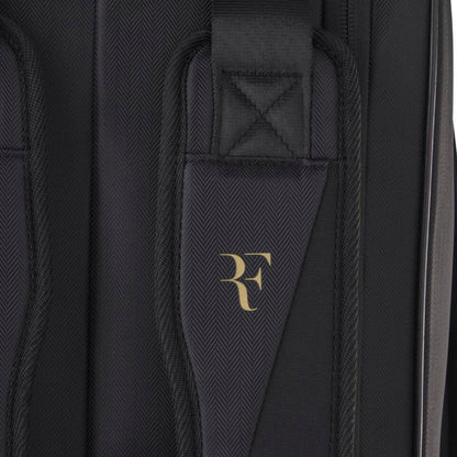 Black tennis bag with a gold logo on a black background
