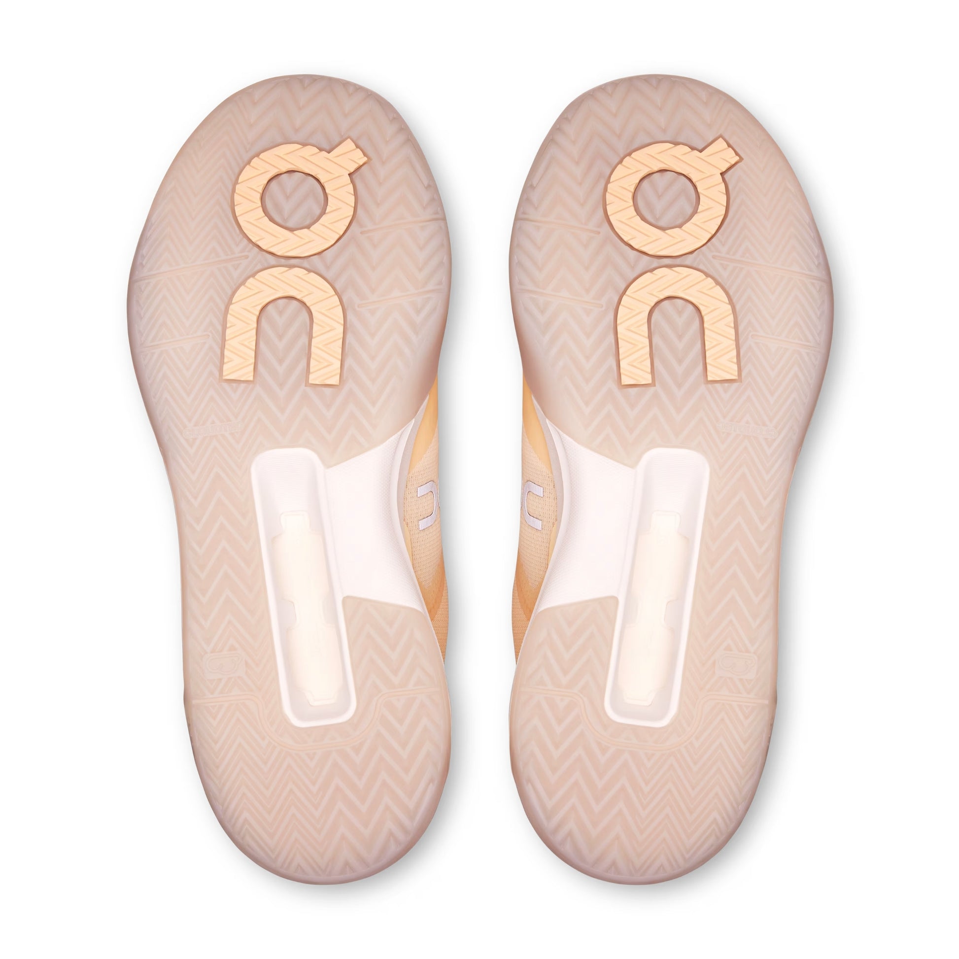 Top-down view of a pair of On shoe soles in a pale peach-beige color with a chevron pattern and a large metallic gold 'on' logo on each.
