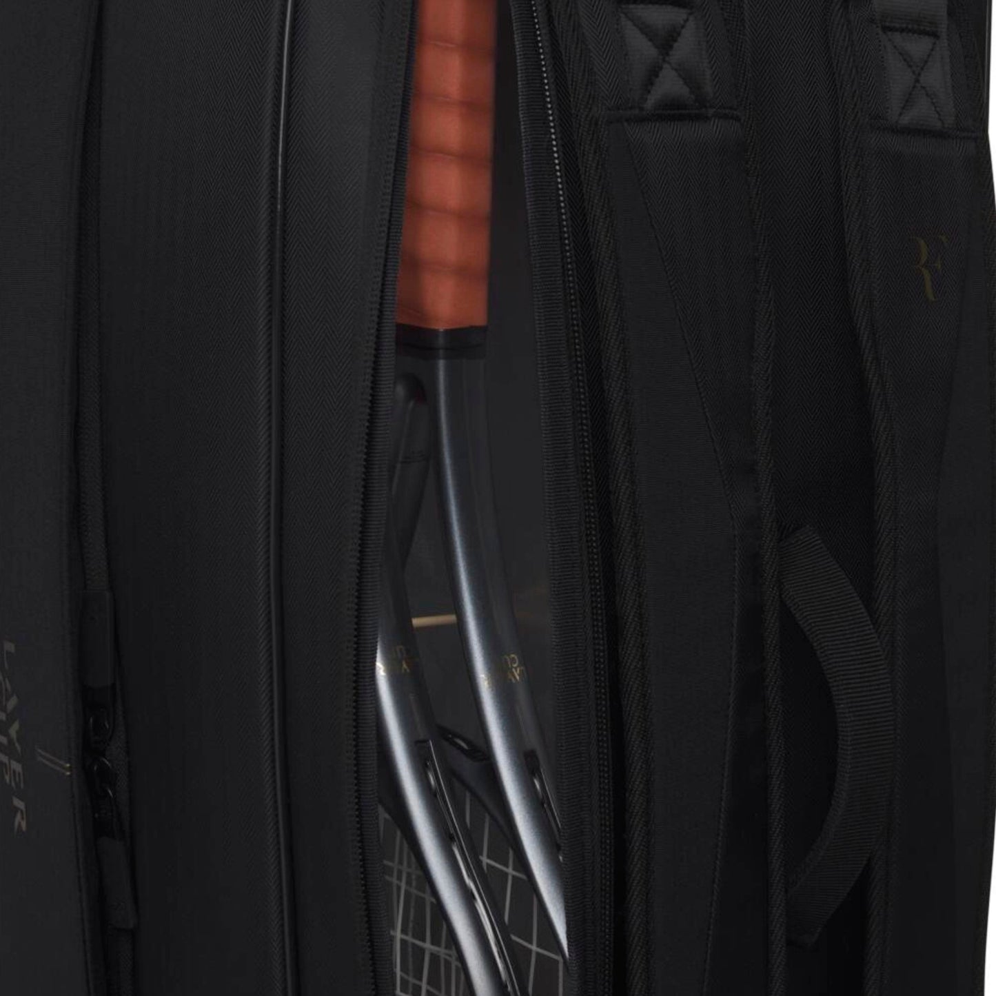 Close-up of a blacktennis bag with a clear compartment revealing a bow inside.