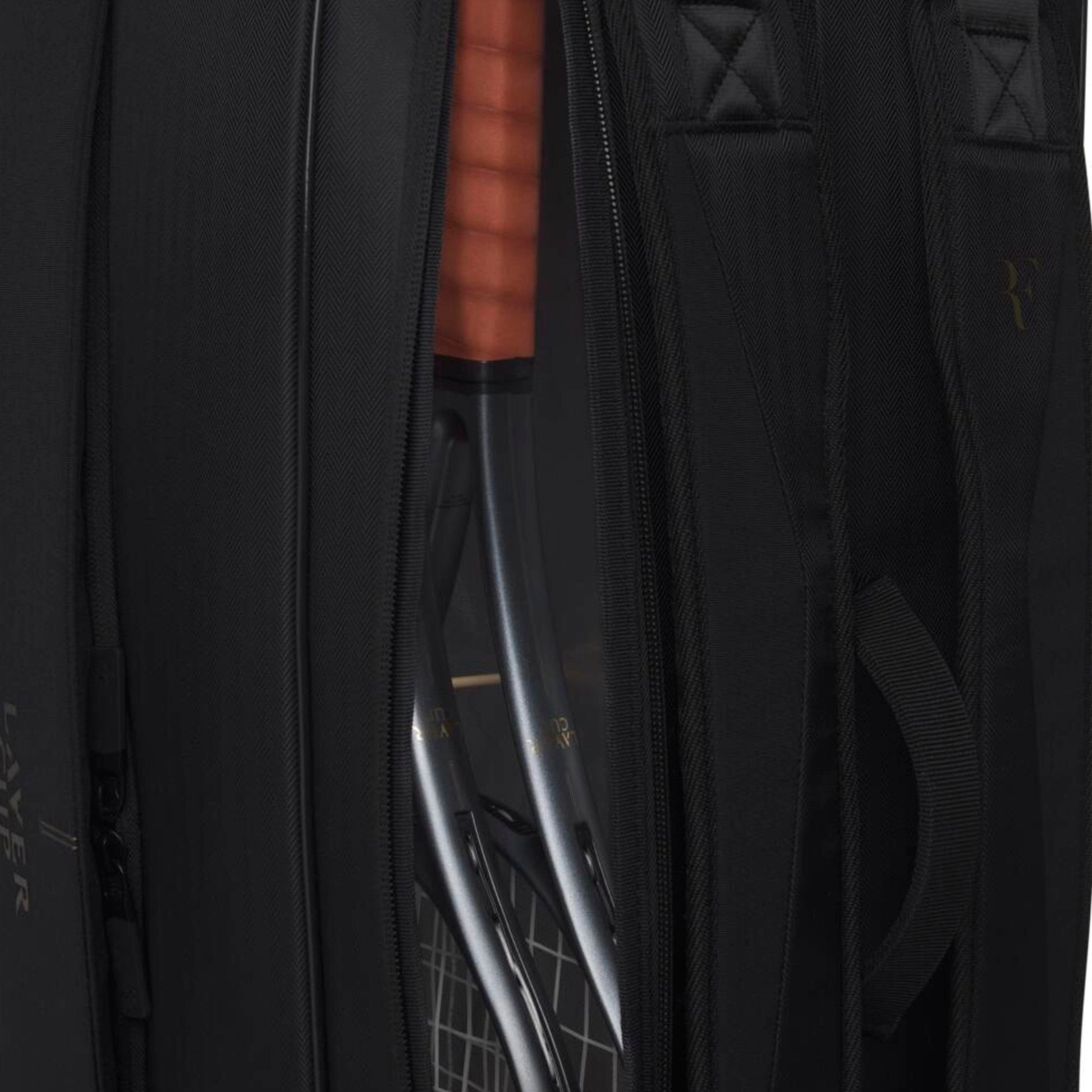 Close-up of a blacktennis bag with a clear compartment revealing a bow inside.