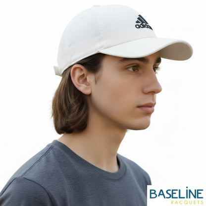 Person wearing white Adidas cap on a white background