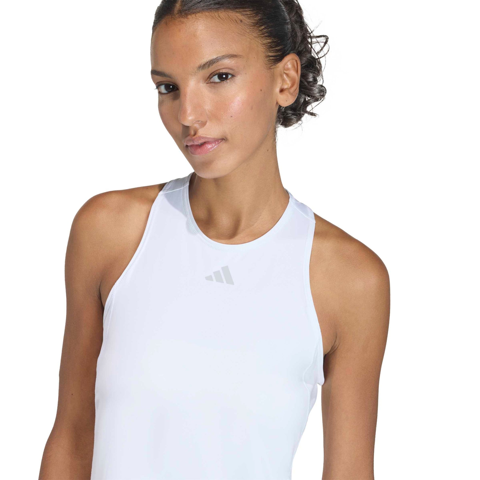 Woman wearing a white adidas dress top on a white background