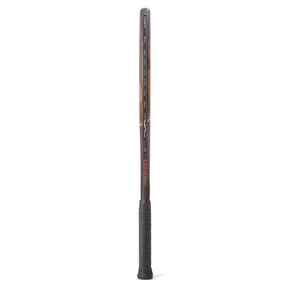 A side view of a brown and range Yonex tennis racket with a black grip on a white background
