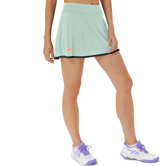 Light green Asics tennis skirt worn by a person on a white background