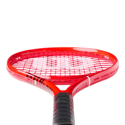 A close-up of a red Wilson tennis racket head with black and white stringing and a black grip, shown against a plain white background.