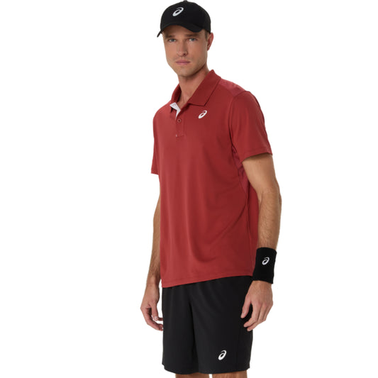 Man wearing a red polo Asics shirt and black shorts with a white background