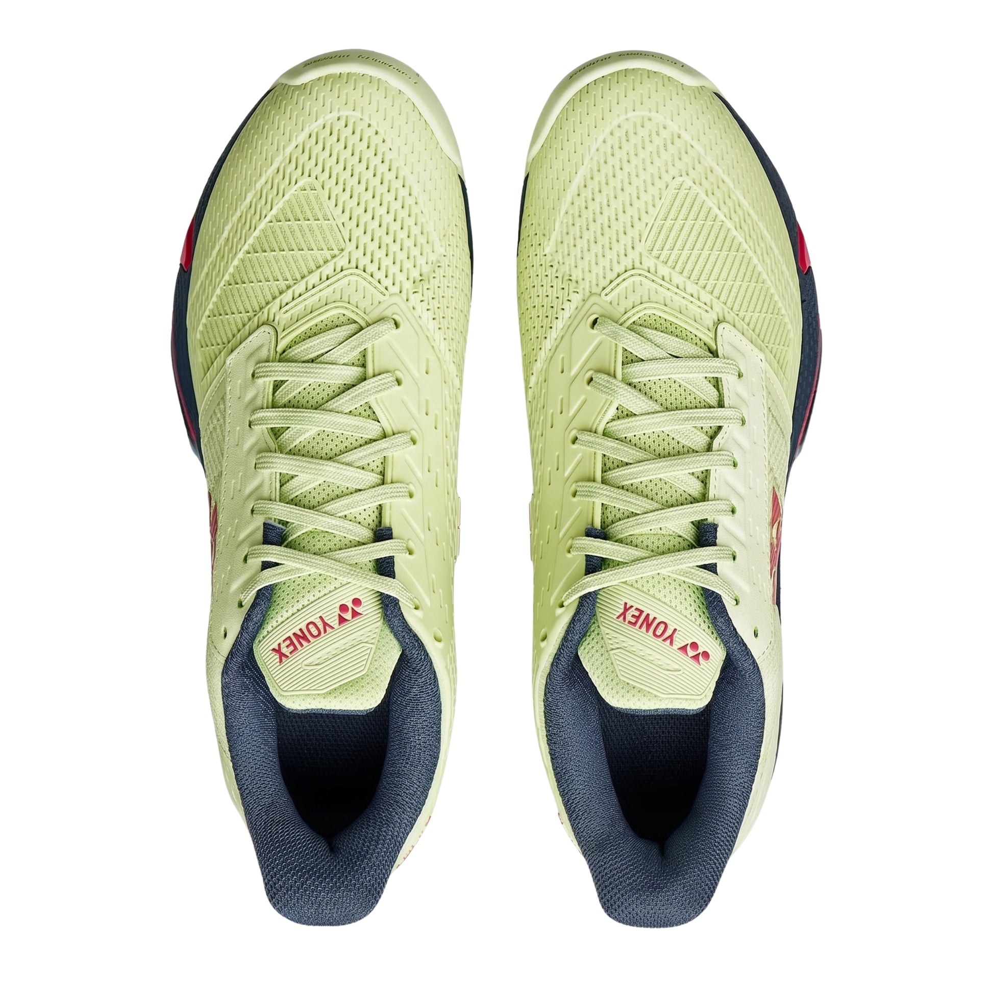 Pair of green Yonex tennis shoes with navy soles on a white background