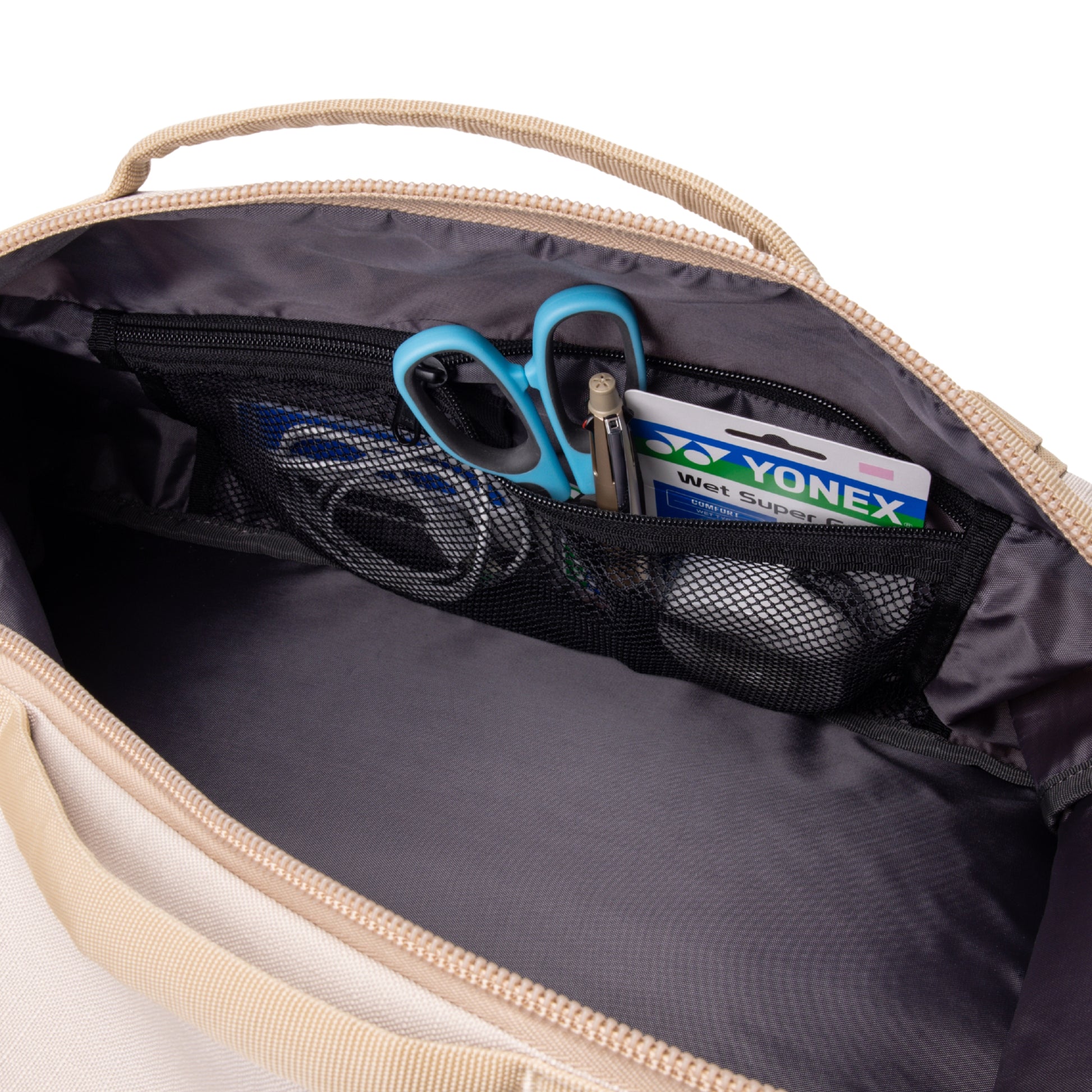 Open bag with Yonex packaging items and blue scissors inside