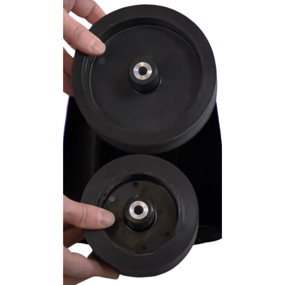 Close-up of a black wheel assembly held by a hand on a white background