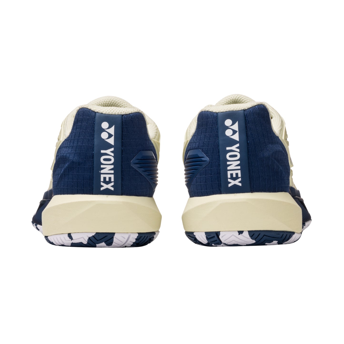 Navy and beige Yonex tennis shoes on a white background