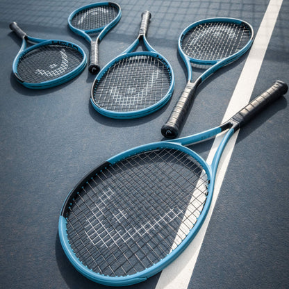 Four blue Head tennis rackets on a dark surface