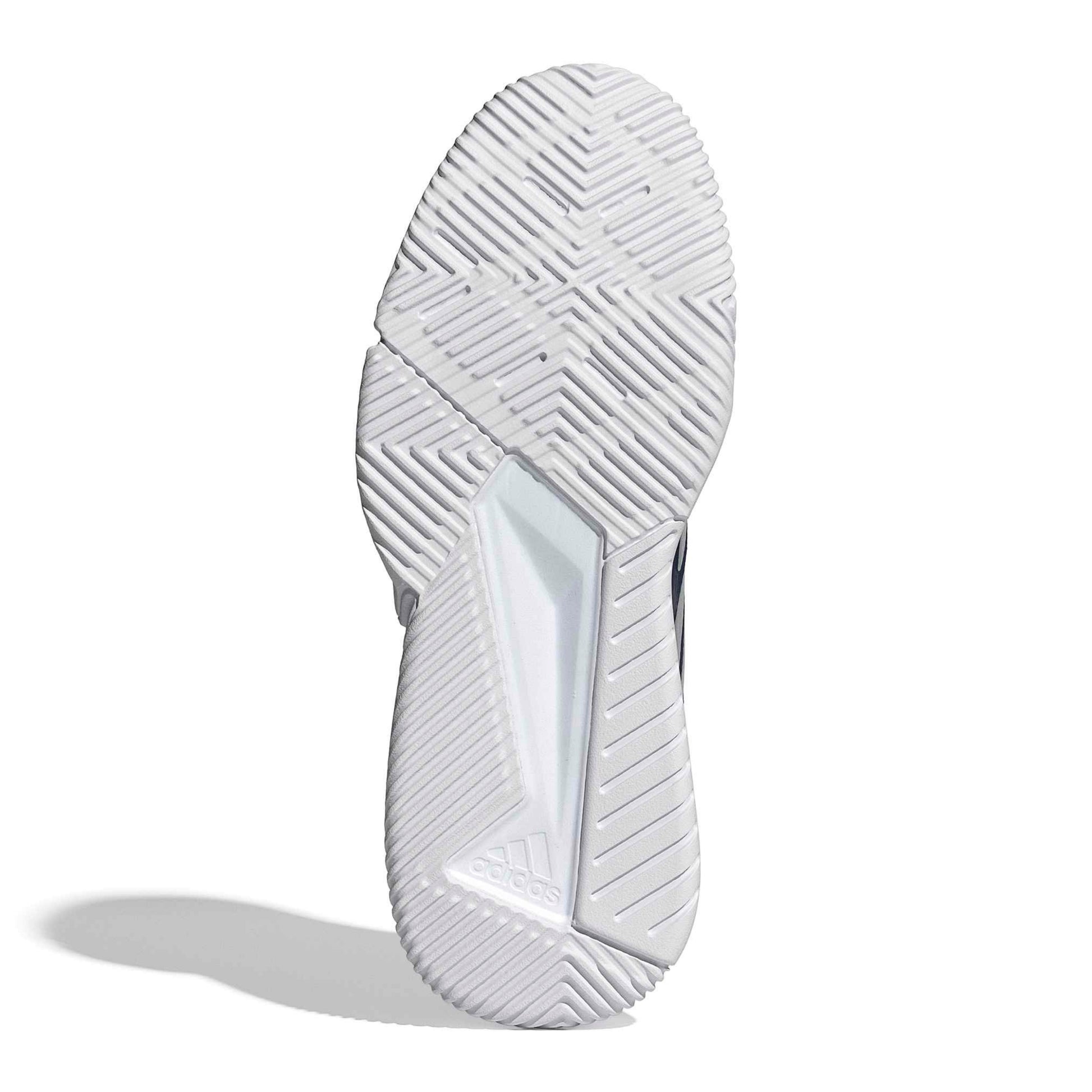 Bottom view of a padidas padel shoe with a white tread pattern shoe sole on a white background