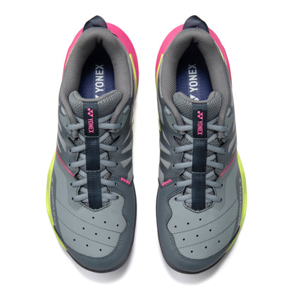 Gray Yonex squash shoes with pink and yellow accents on a white background