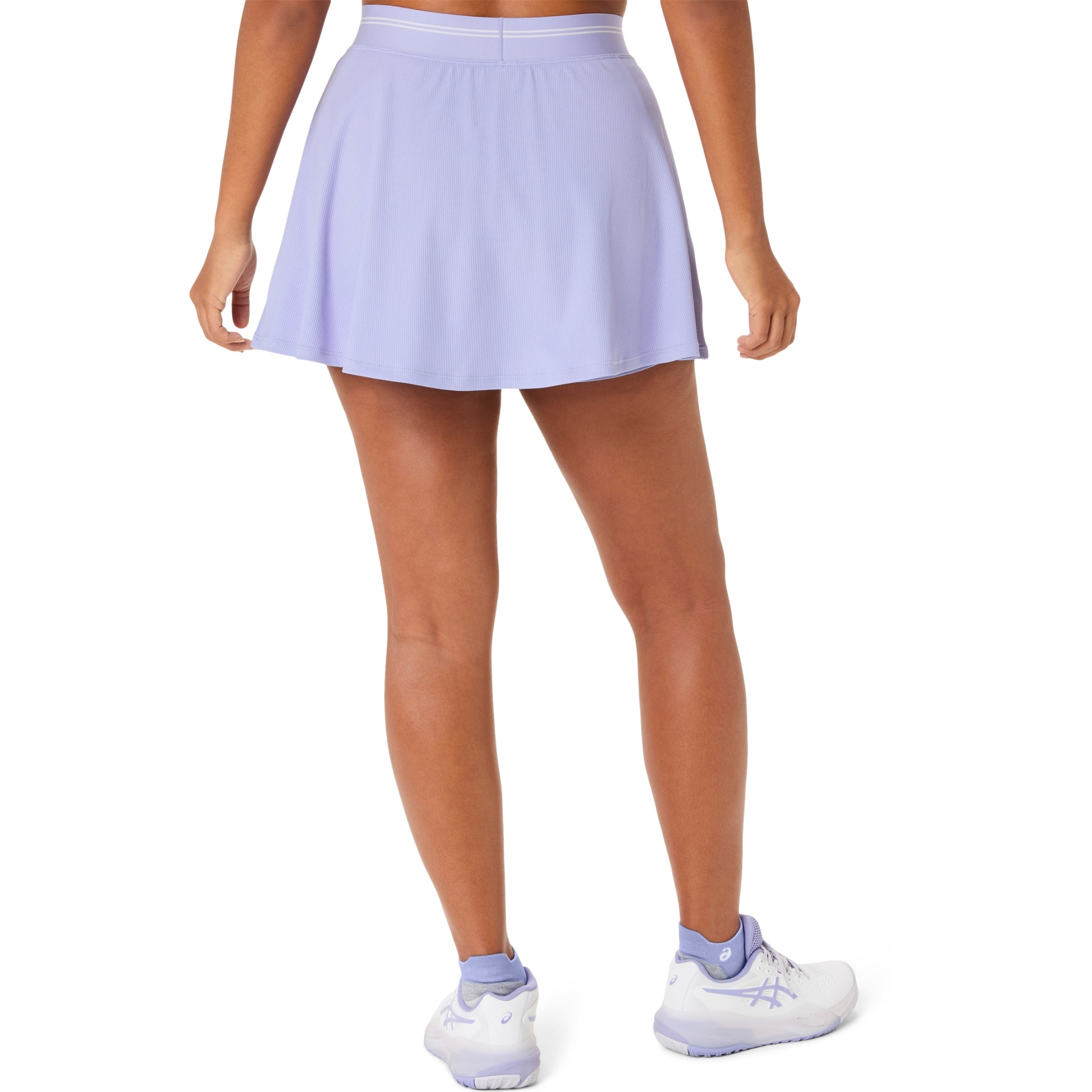 Person wearing a light purple tennis skirt and white shoes on a white background