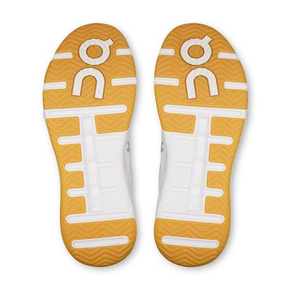Bottom view of on tennis shoes with a tread pattern sole on a white background
