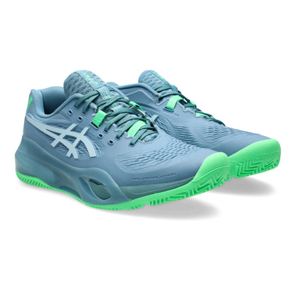 Blue padel shoes with green soles on a white background