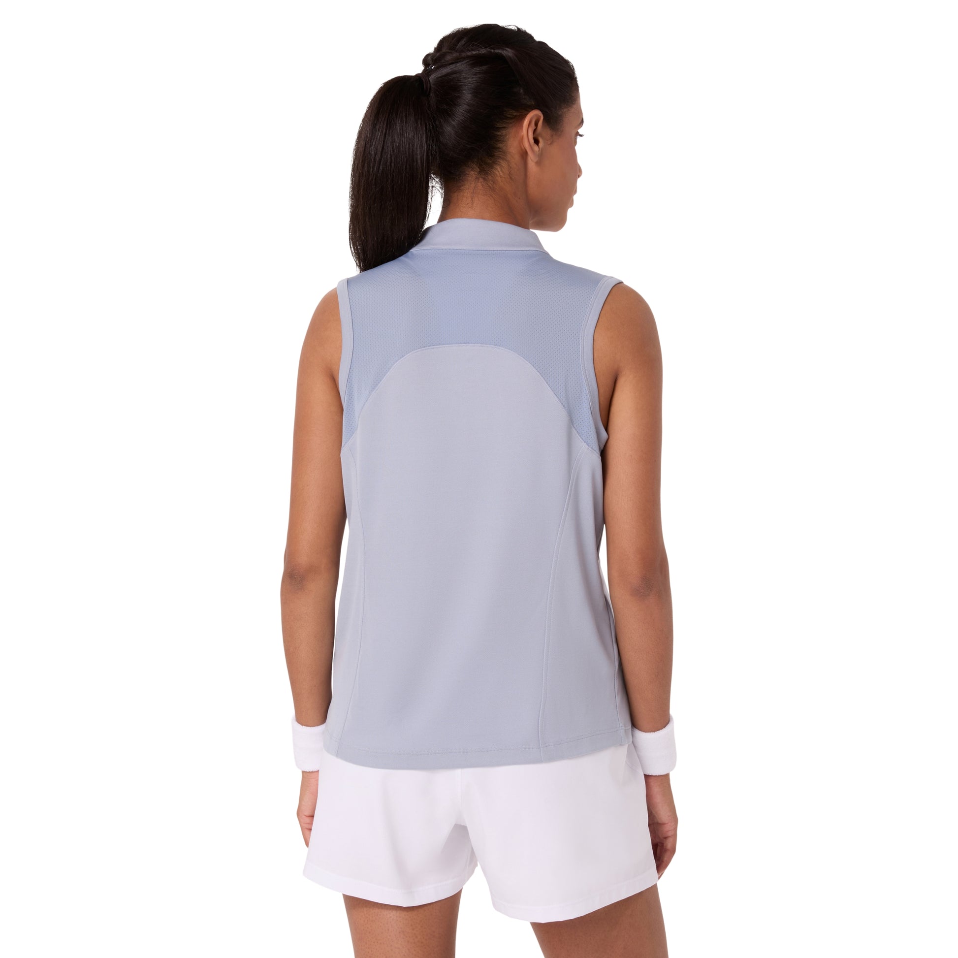 Woman wearing a sleeveless light blue top and white shorts on a white background