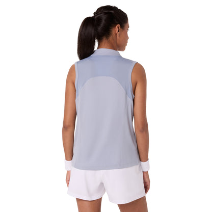 Woman wearing a sleeveless light blue top and white shorts on a white background