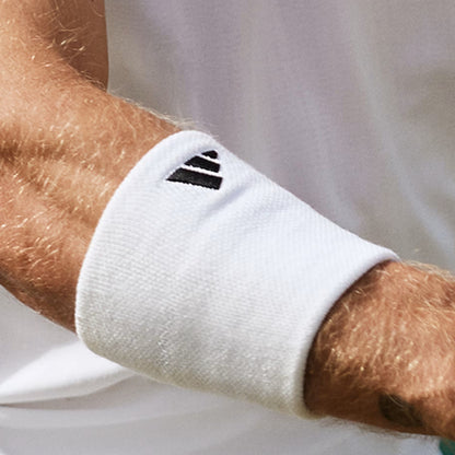 White wristband with Adidas logo on a person's wrist