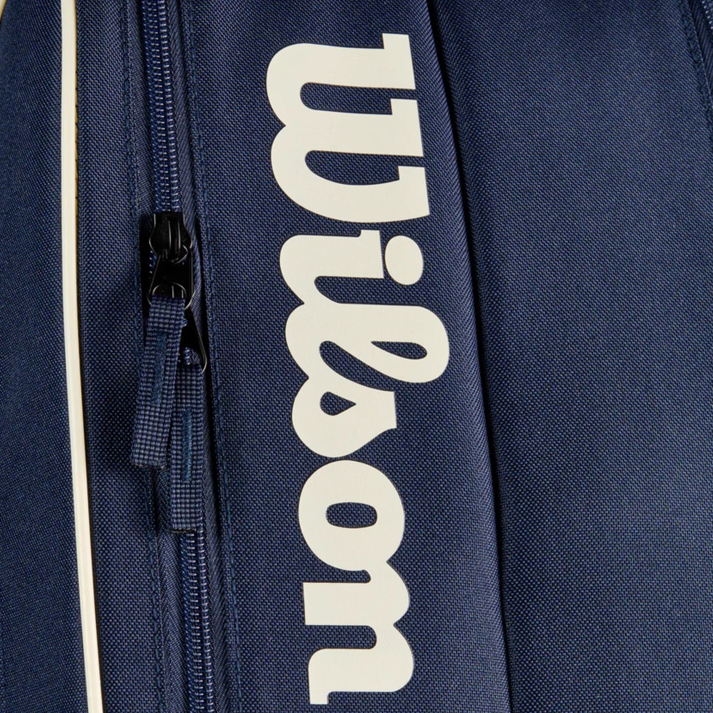 Navy blue tennis bag with 'Wilson' logo in white on a dark background