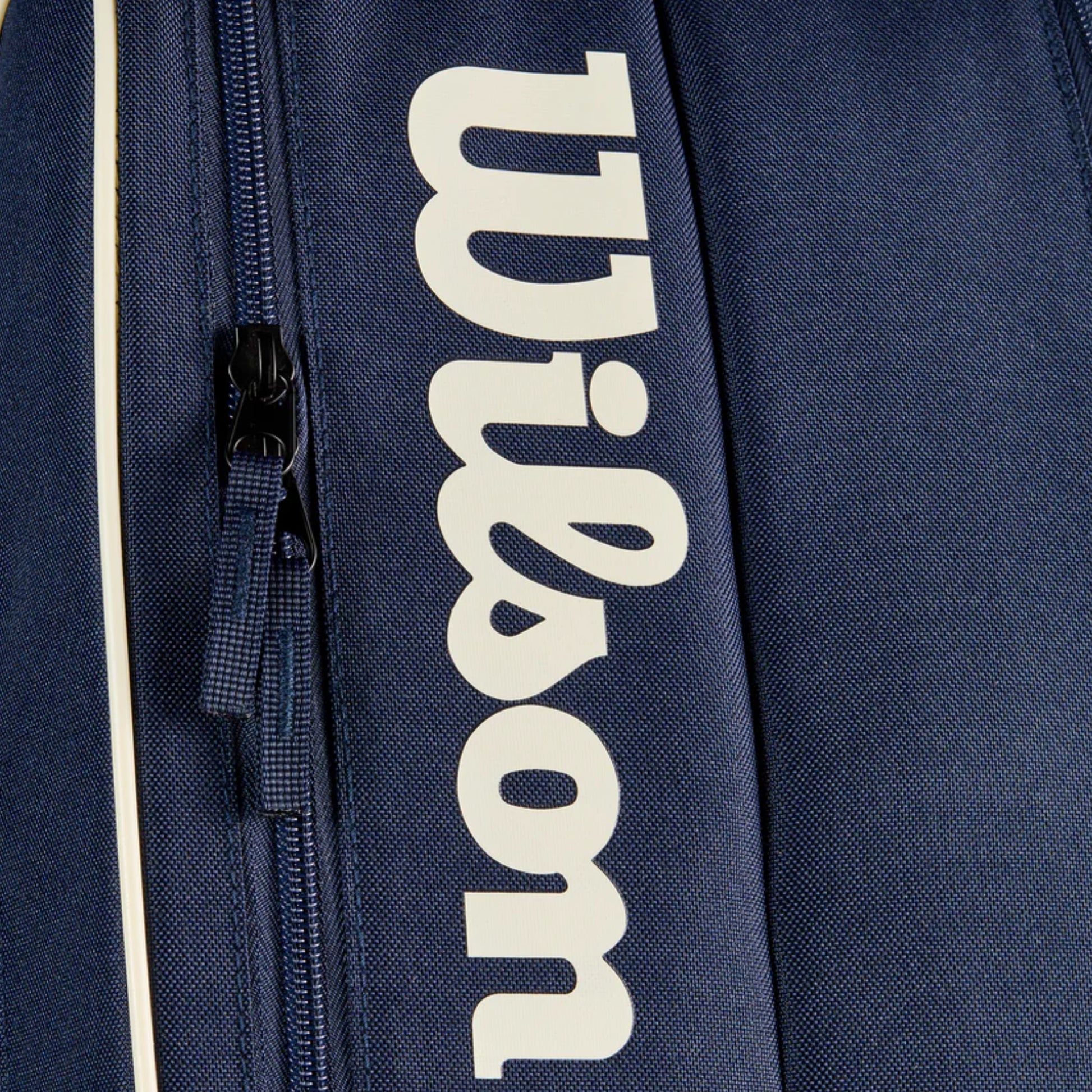 Navy blue tennis bag with 'Wilson' logo in white on a dark background
