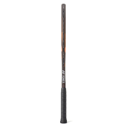 A side view of a brown and range Yonex tennis racket with a black grip on a white background