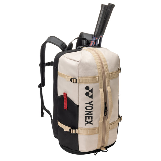 Beige Yonex backpack with tennis rackets on a white background
