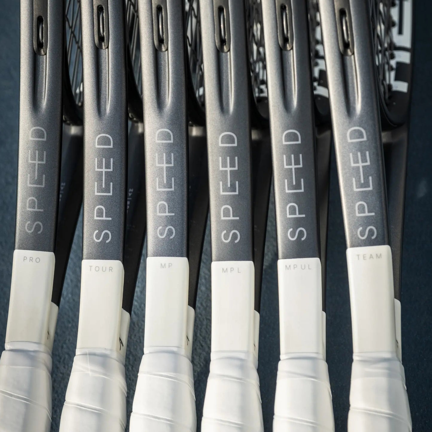 Multiple tennis rackets with 'SPEED' branding on a dark background