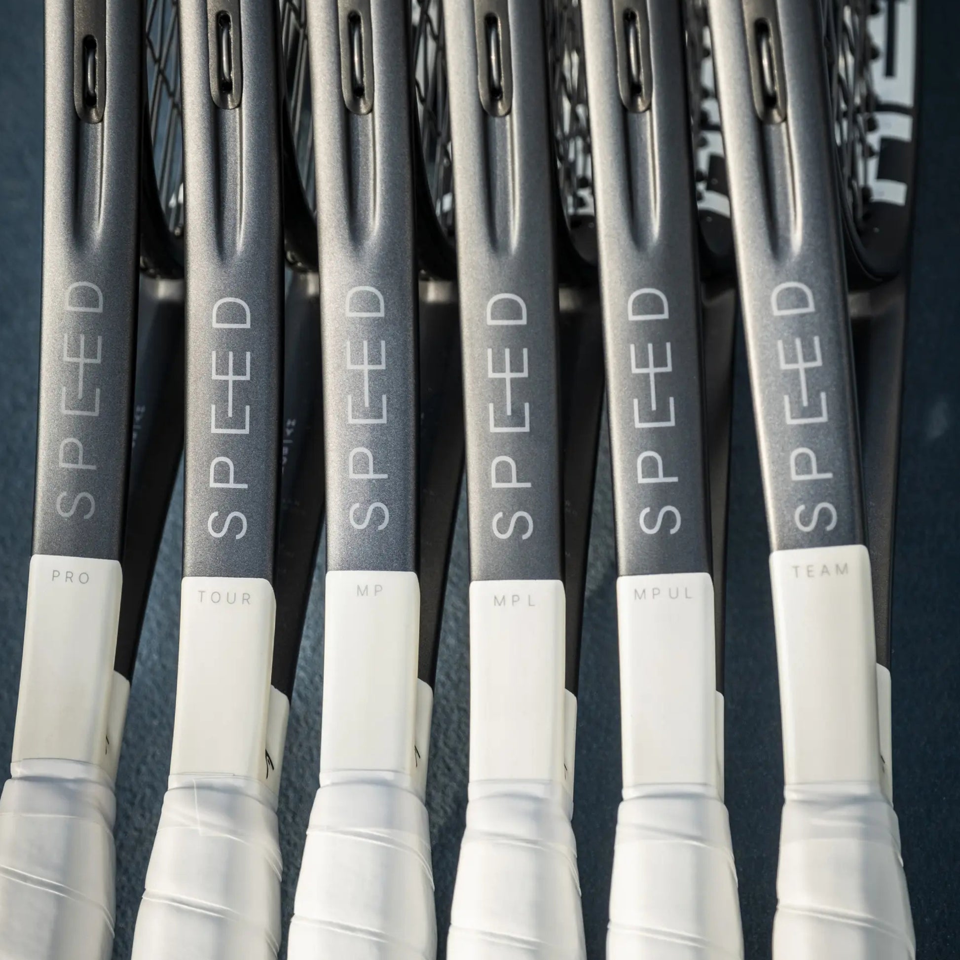 Multiple tennis rackets with 'SPEED' branding on a dark background