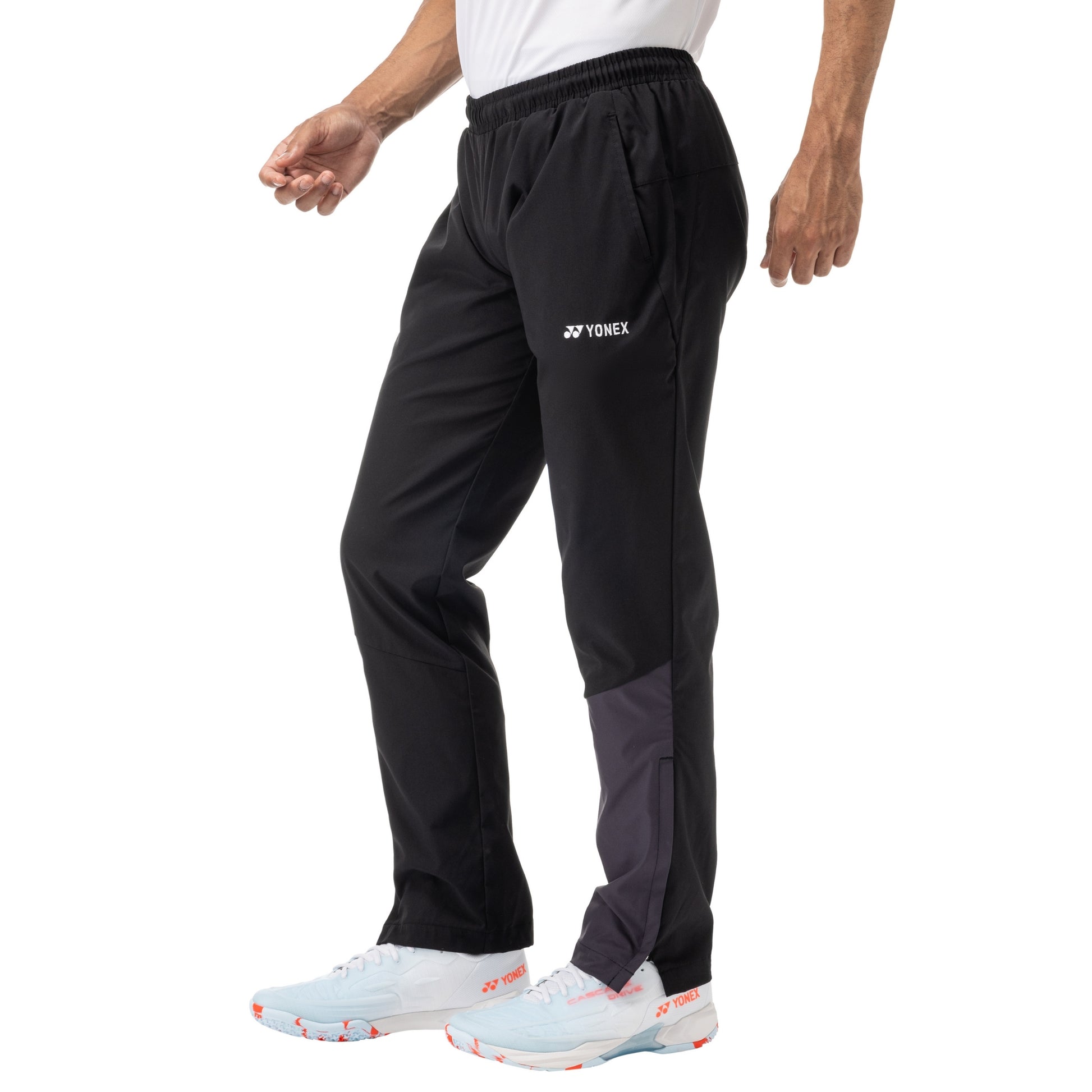 Person wearing black Yonex sports pants on a white background