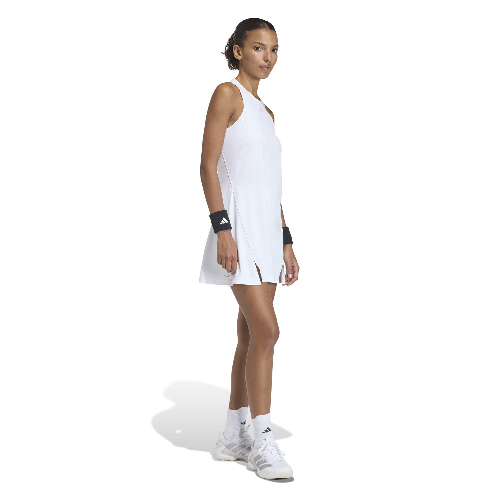 Woman wearing a white tennis adidas dress on a white background