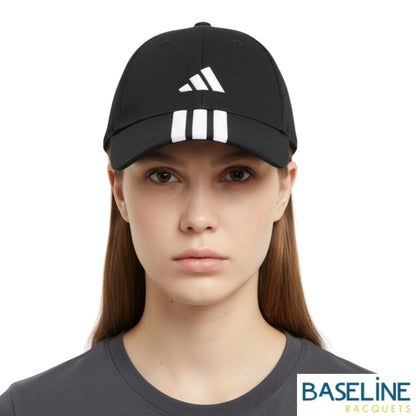 Person wearing a black striped cap with adidas logo on a white background