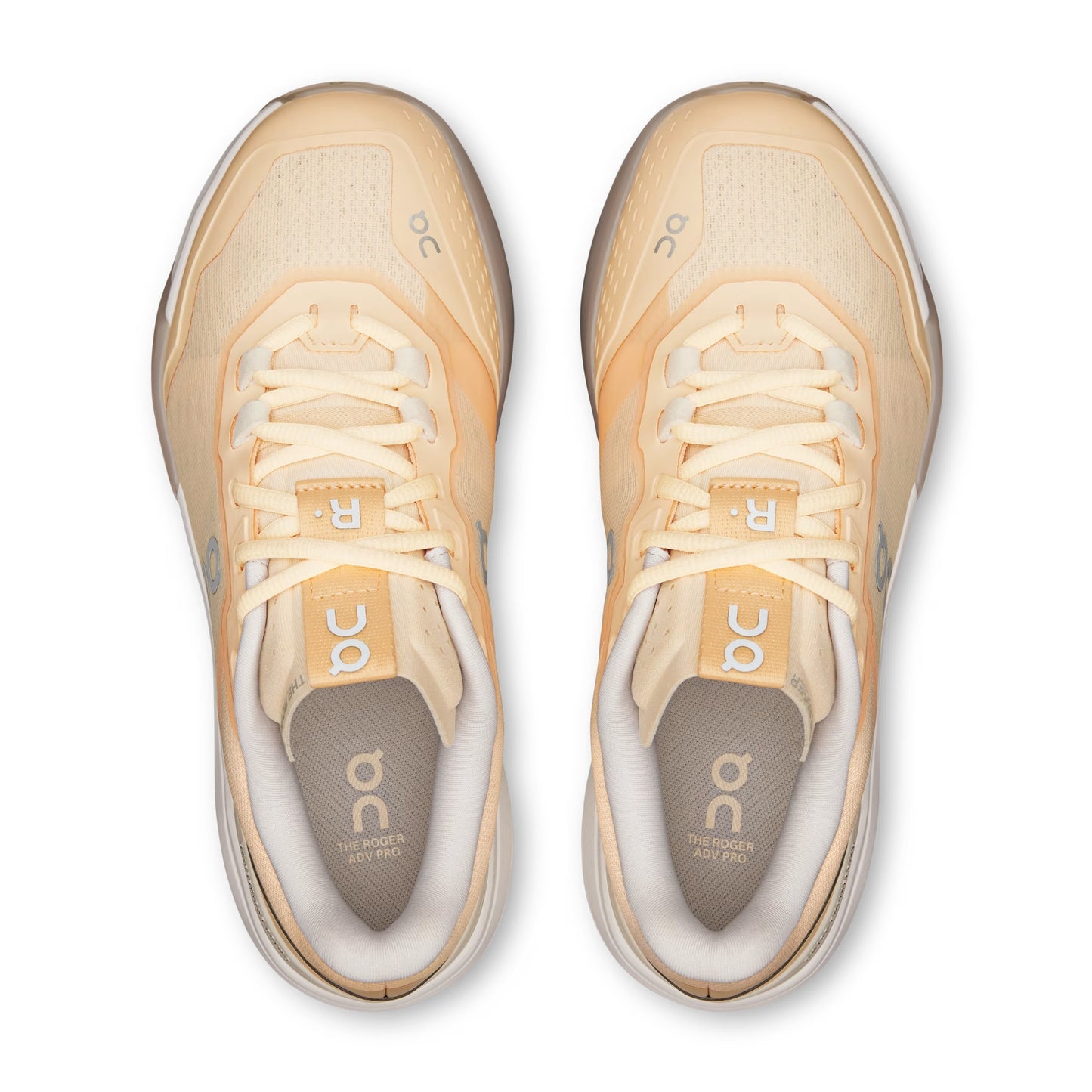 A pair of On running shoes in a light peach and cream colorway, shown from a top-down view on a white background.