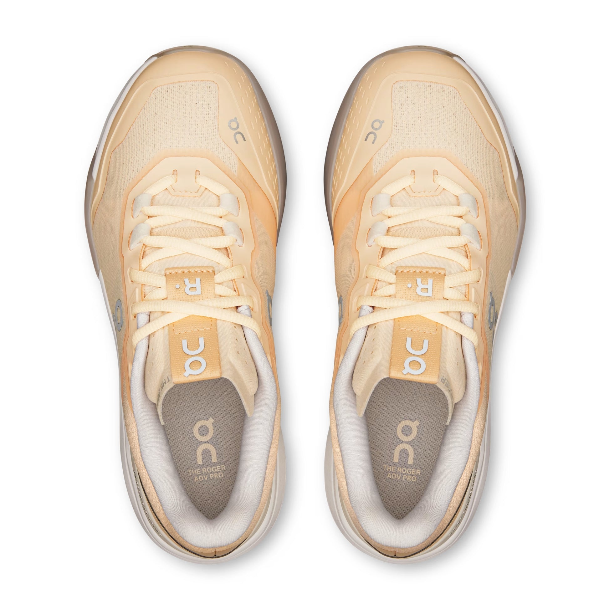 A pair of On running shoes in a light peach and cream colorway, shown from a top-down view on a white background.