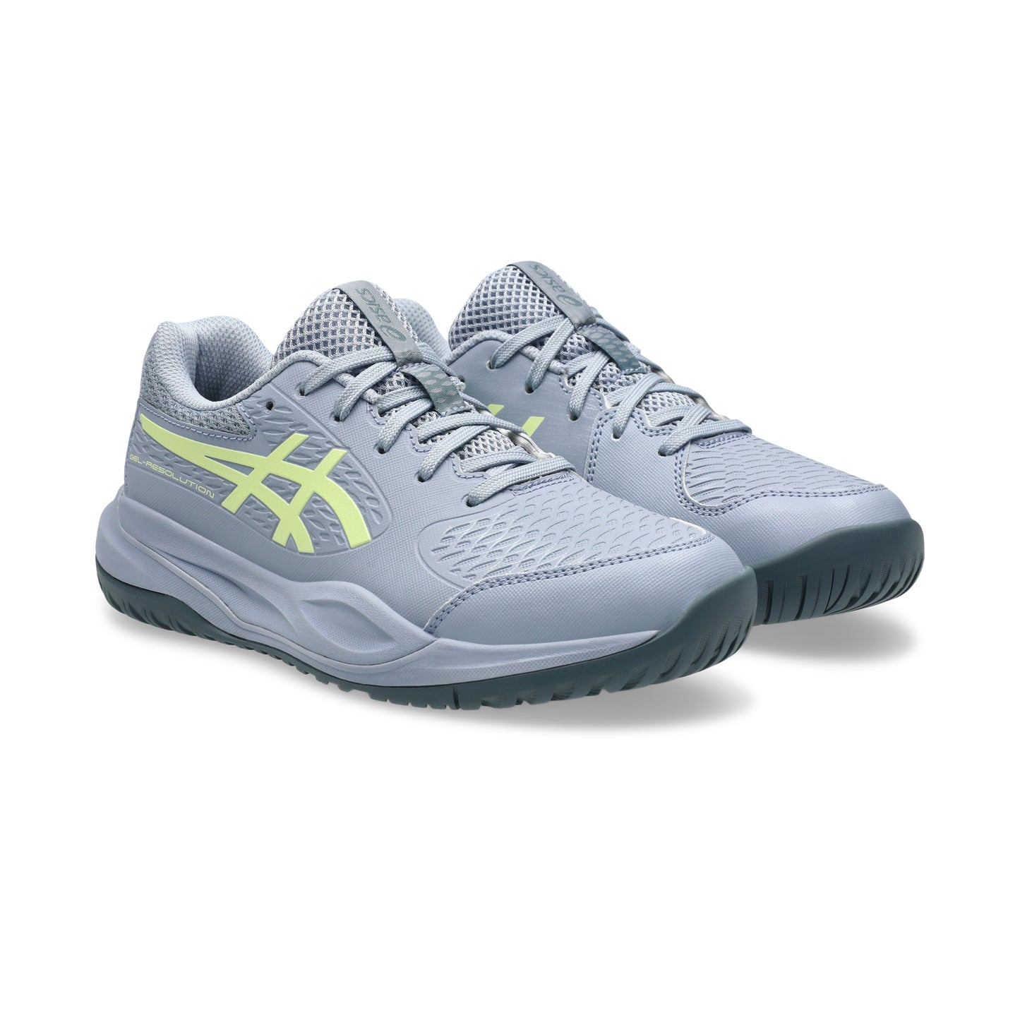 Pair of gray tennis shoes with green accents on a white background