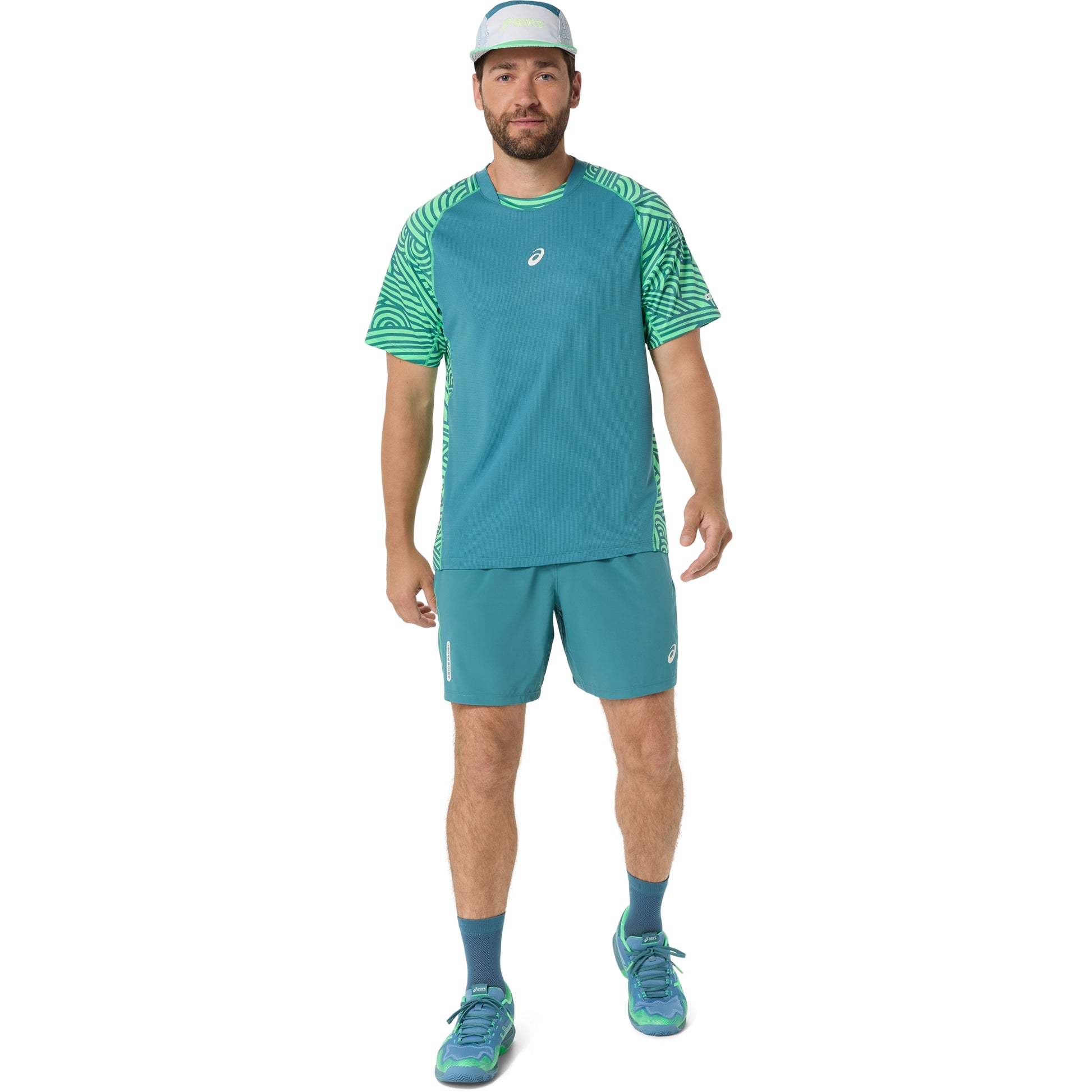 Man wearing a teal athletic outfit with a logo on a white background