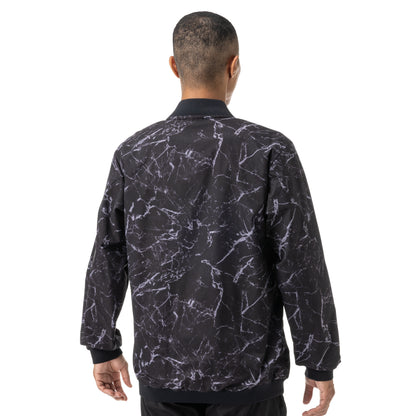 Man wearing a black and white patterned Yonex jersey on a white background