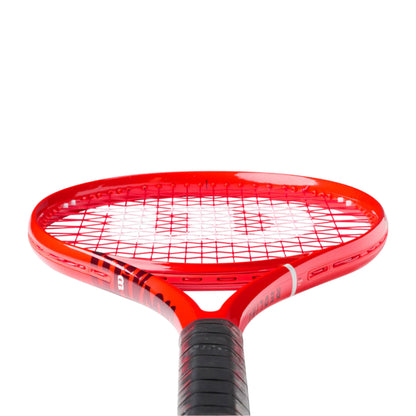 A close-up of a Wilson red tennis racket head and upper handle with a black grip, shown against a plain white background.