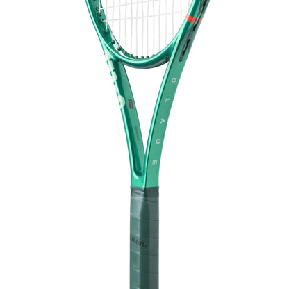 Close-up of a green Wilson tennis racket with 'Blade' branding on a white background