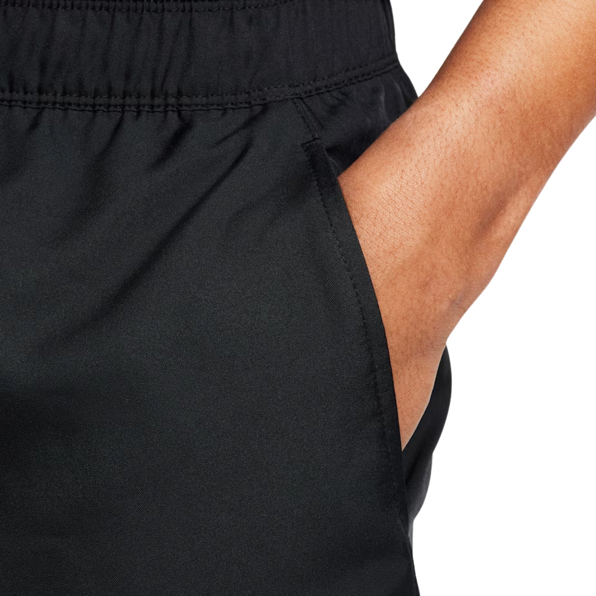 Close-up of a person wearing black shorts with a white background